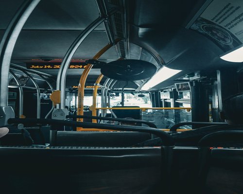 Person reading a book on the Metro bus during evening commute