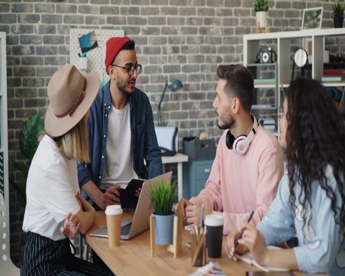 Team of young professionals discussing a project in a coworking space